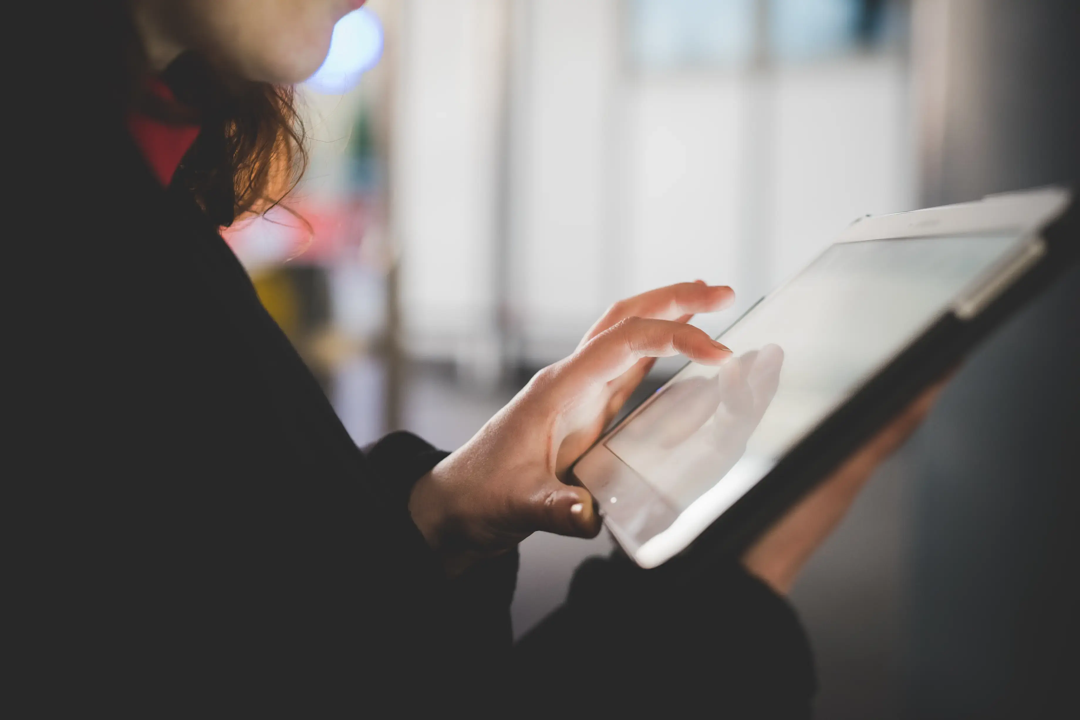 Device-close-up-hands-woman-using-tablet-lit-by-the-screen-night_SaesQWXYJZ