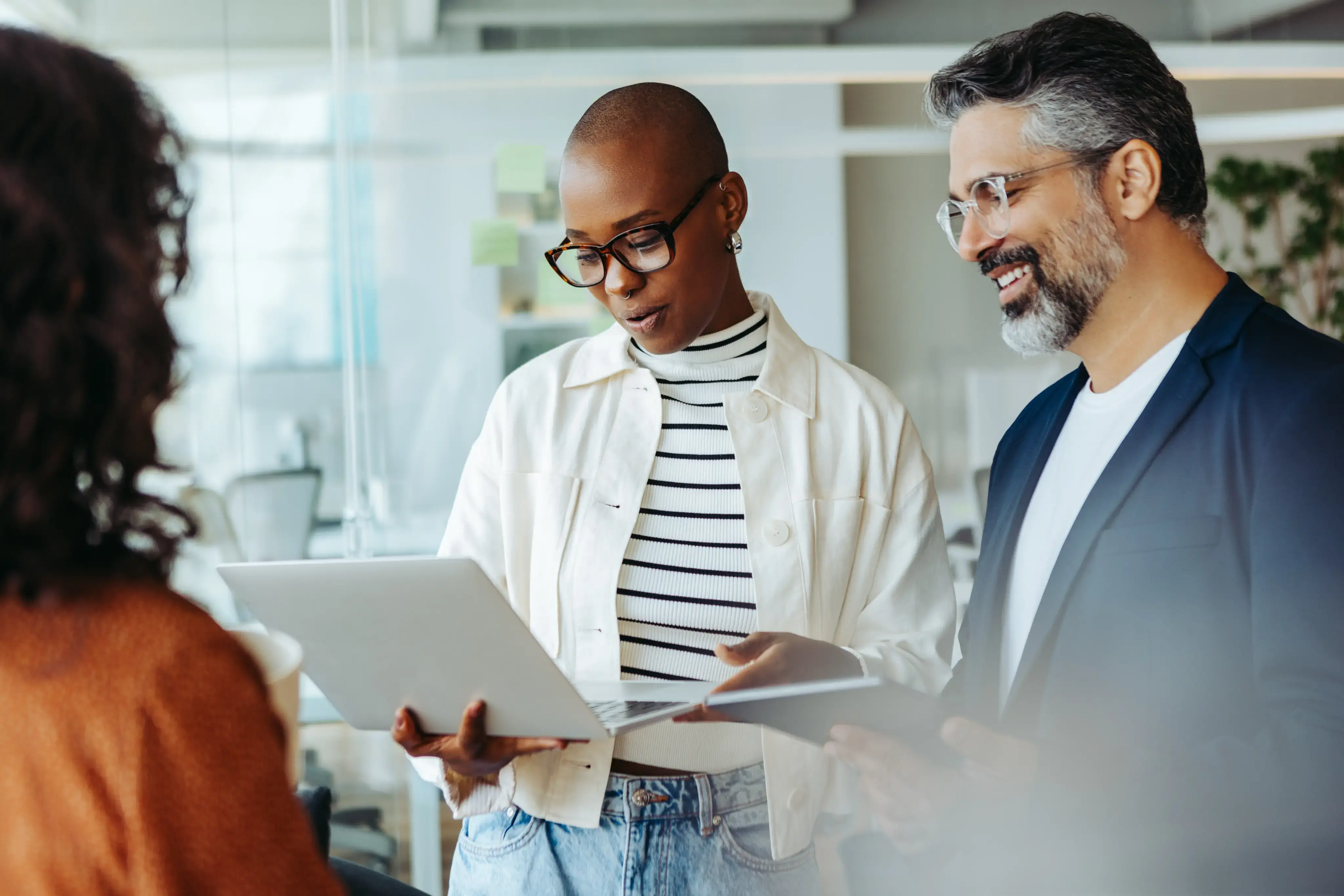 Group of business people having a standup meeting with a laptop in an office