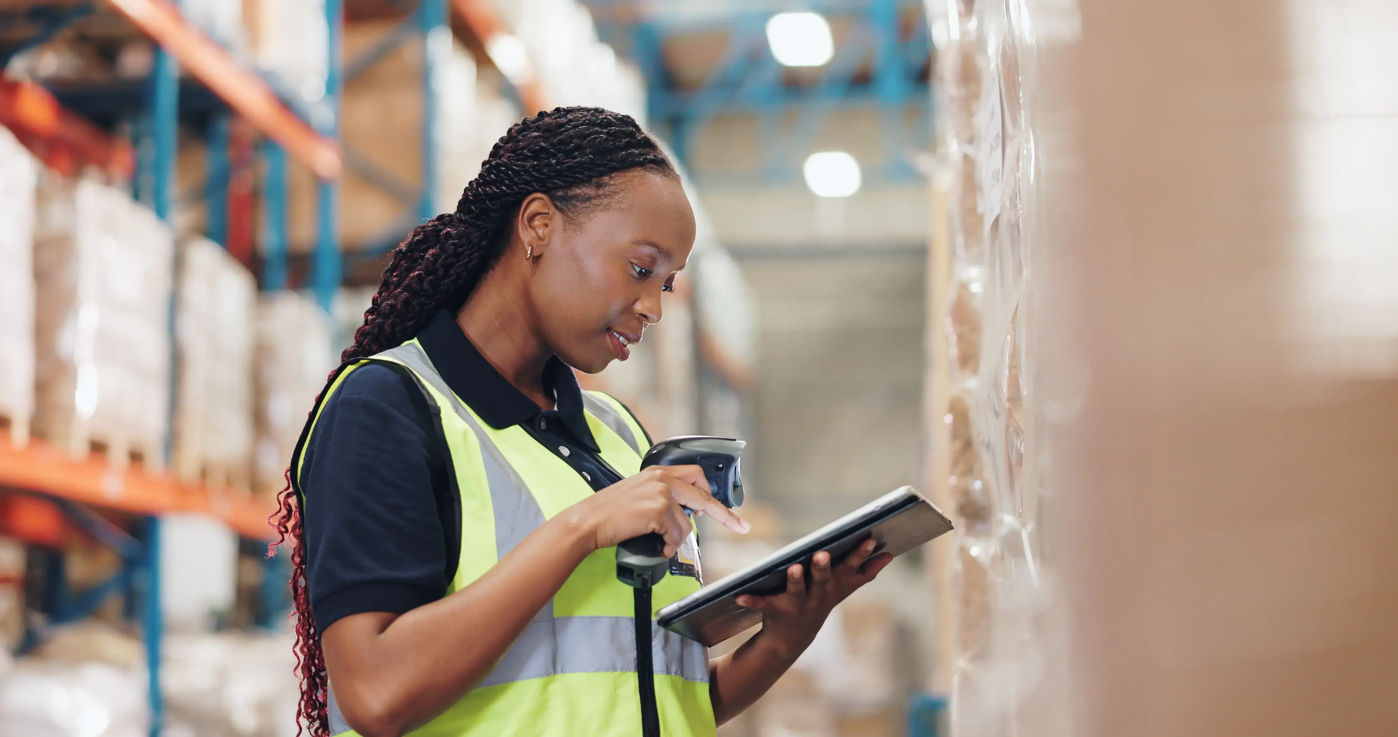 Women using a tablet in a warehouse, inventory checking a parcel